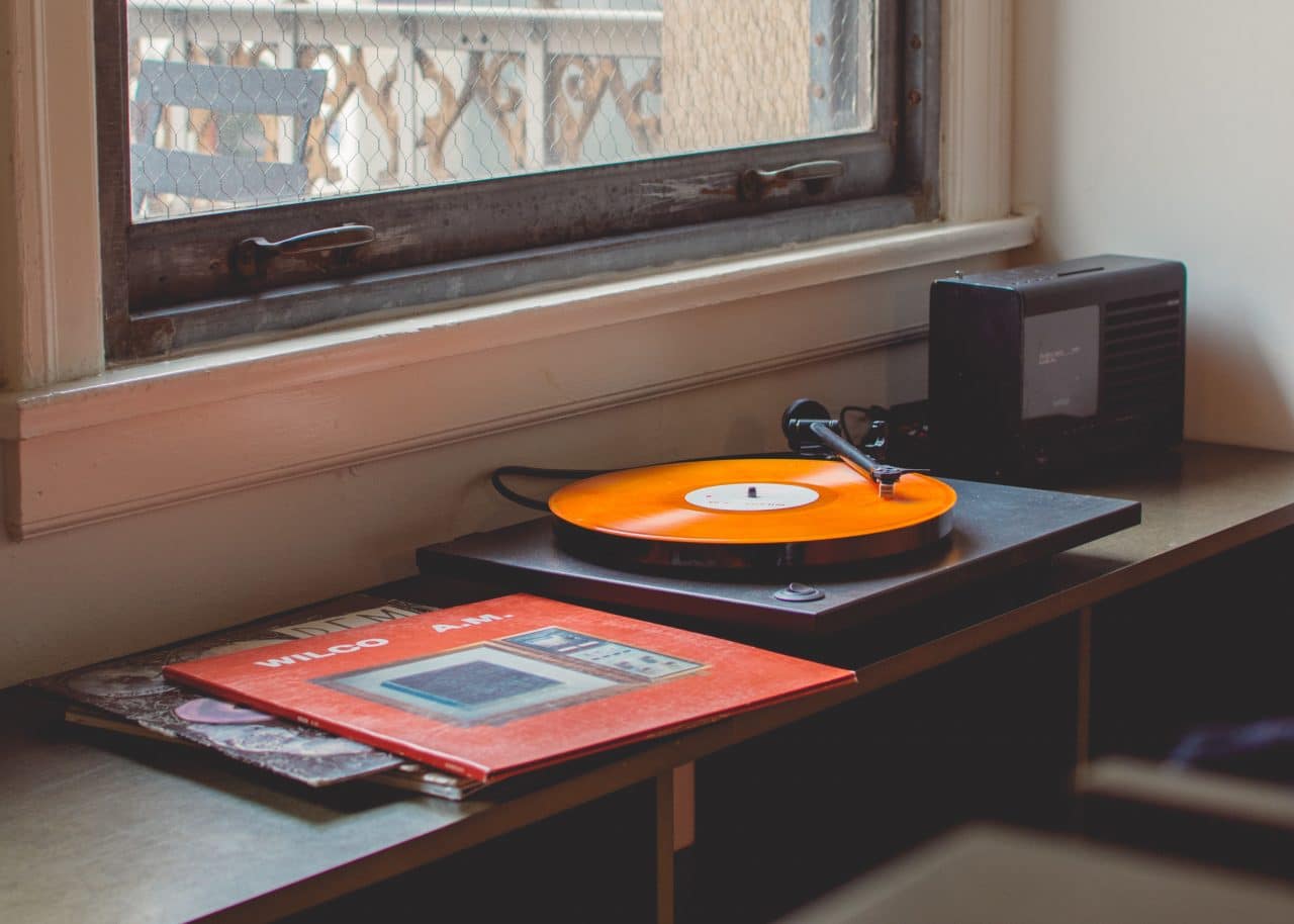 Vinyl records and record player near a window